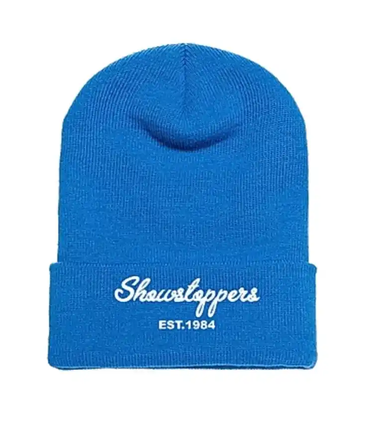 A bright blue knit beanie with Showstoppers EST.1984 written in white text on the folded brim. -Showstoppers Dance Studio